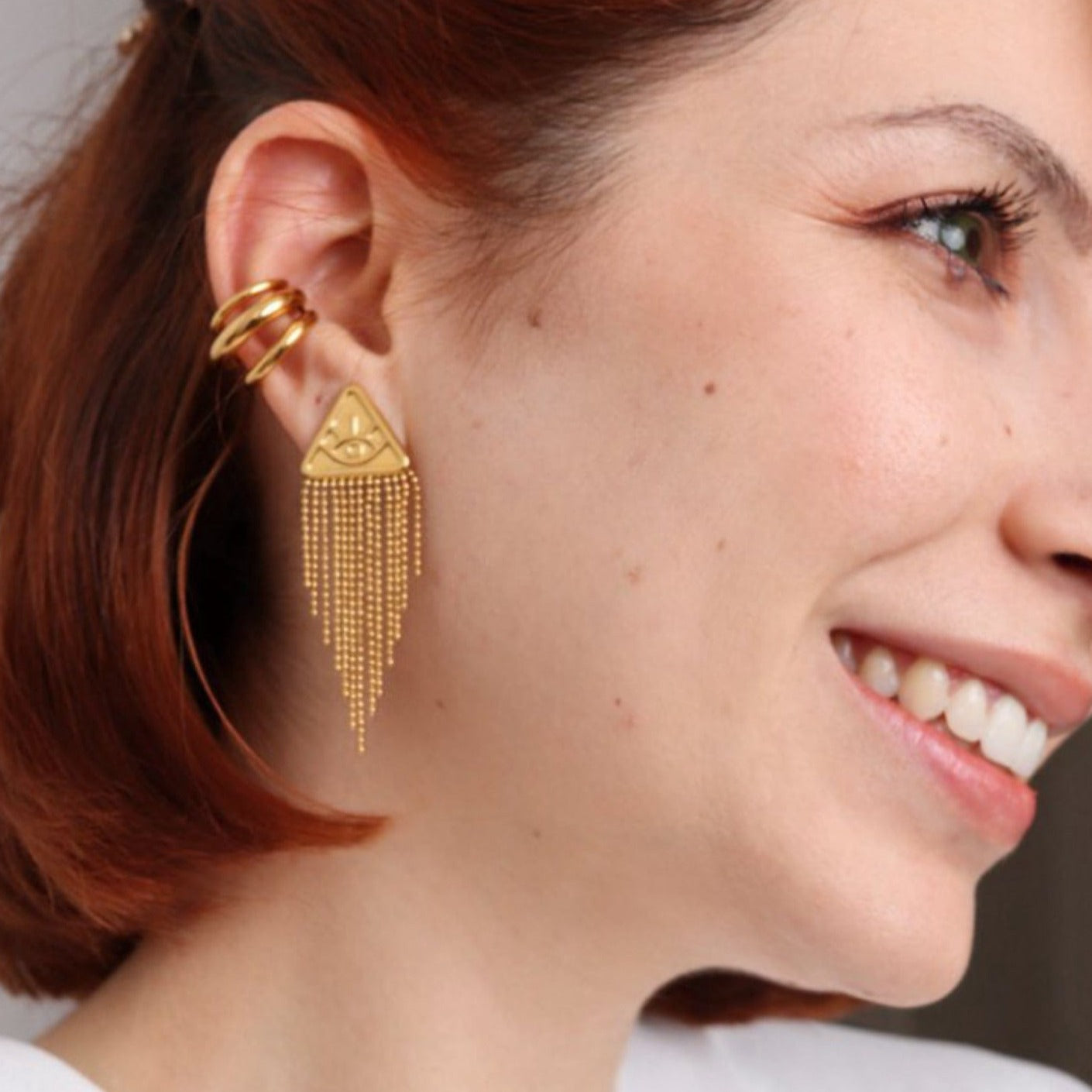 Femme portant les boucles d'oreilles
dorées à longues franges près du visage