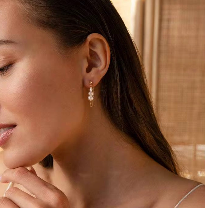 boucles d’oreilles pendantes en acier inoxydable doré à l’or fin, ornées de perles naturelles délicatement sélectionnées. Légères, élégantes et hypoallergéniques