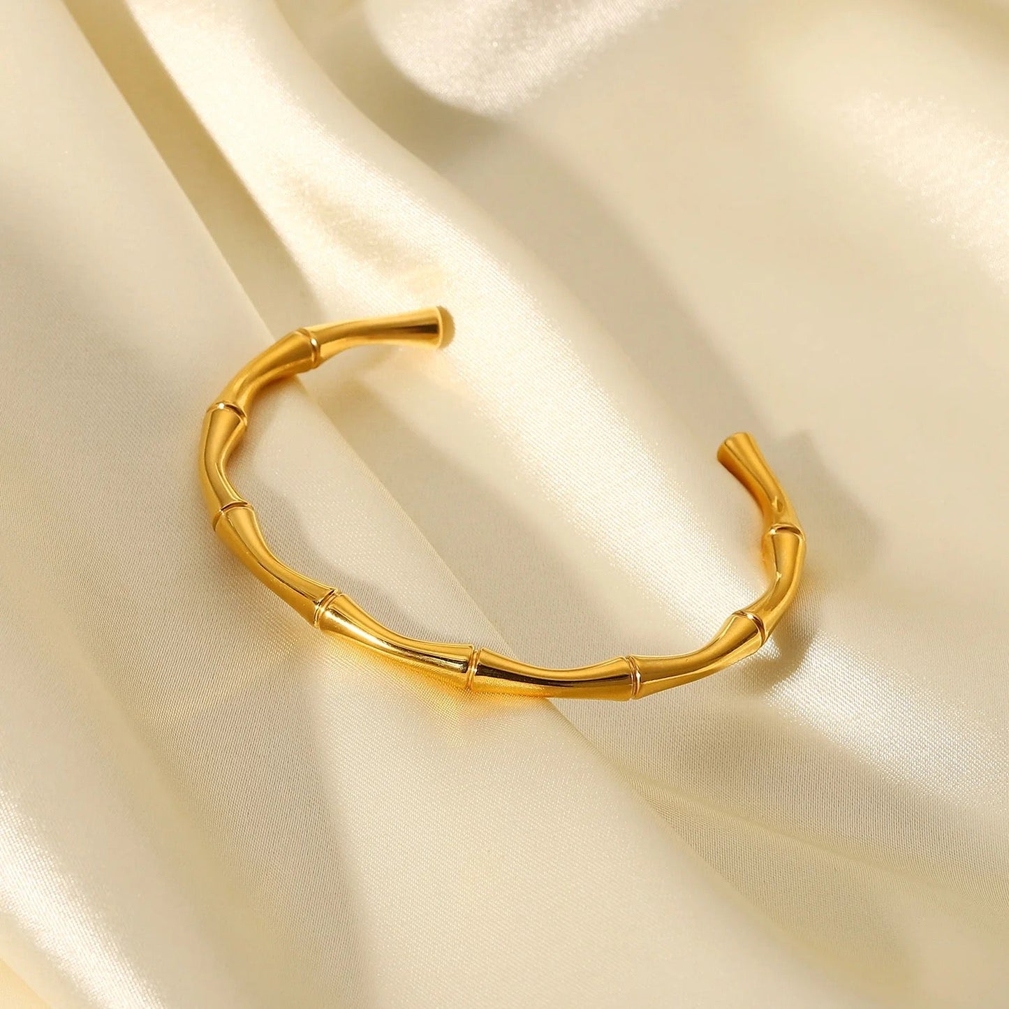 Détail du bracelet jonc ajustable doré sur fond clair