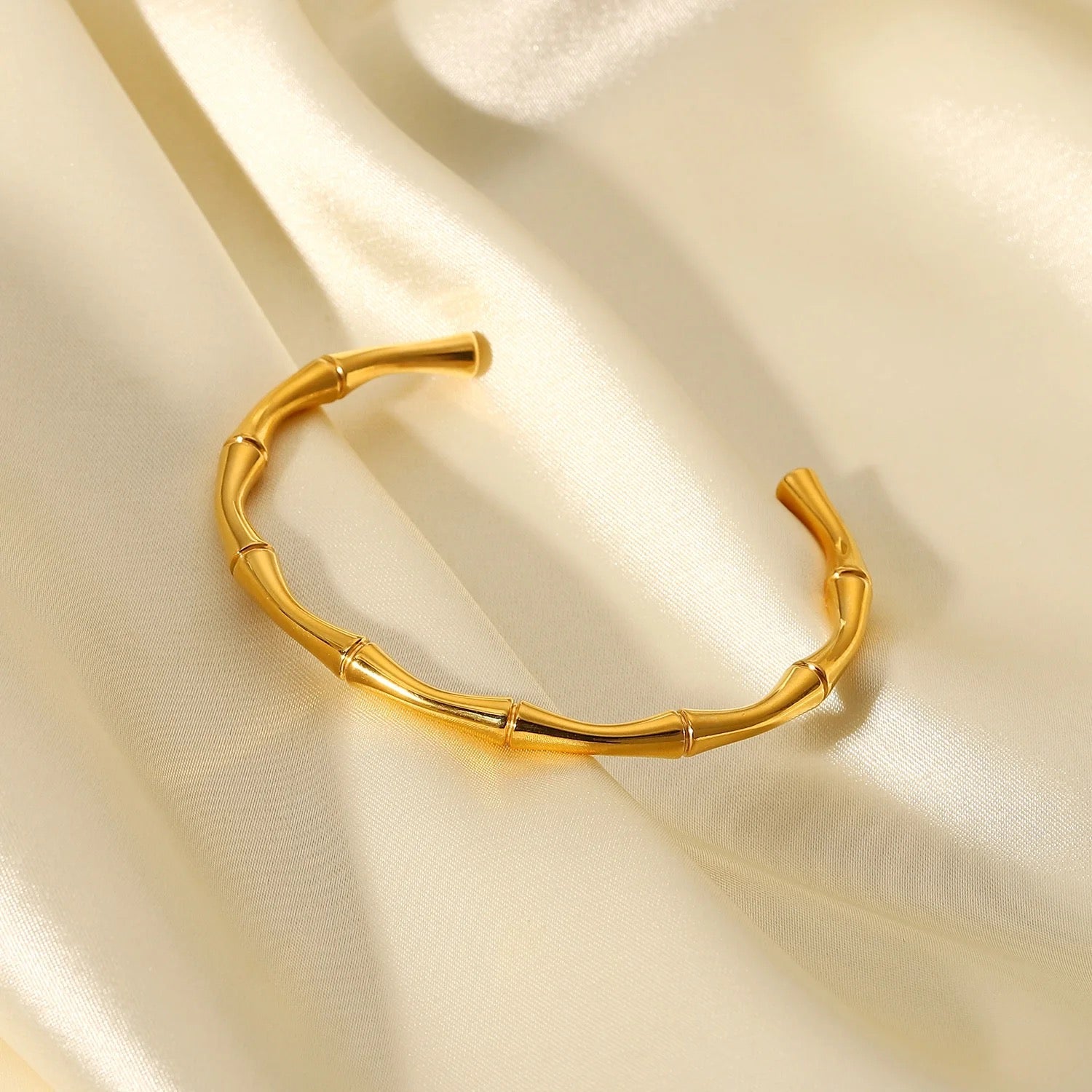 Détail du bracelet jonc ajustable doré sur fond clair