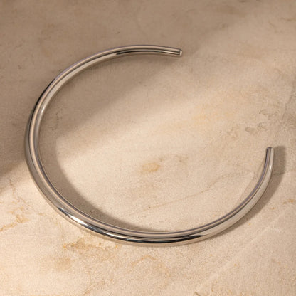 Choker Dalia couleur argentée en acier inoxydable posé sur une pierre beige