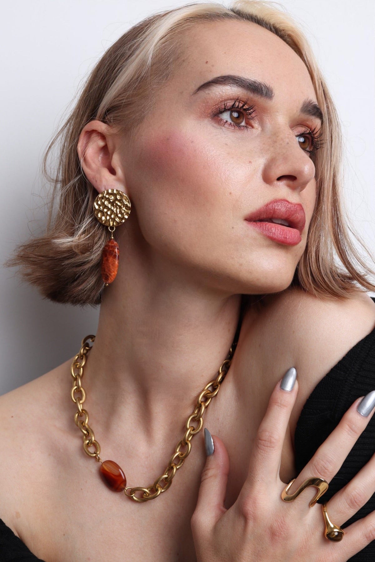 Vue de détail des boucles d'oreilles orange en acier inoxydable, bijou coloré