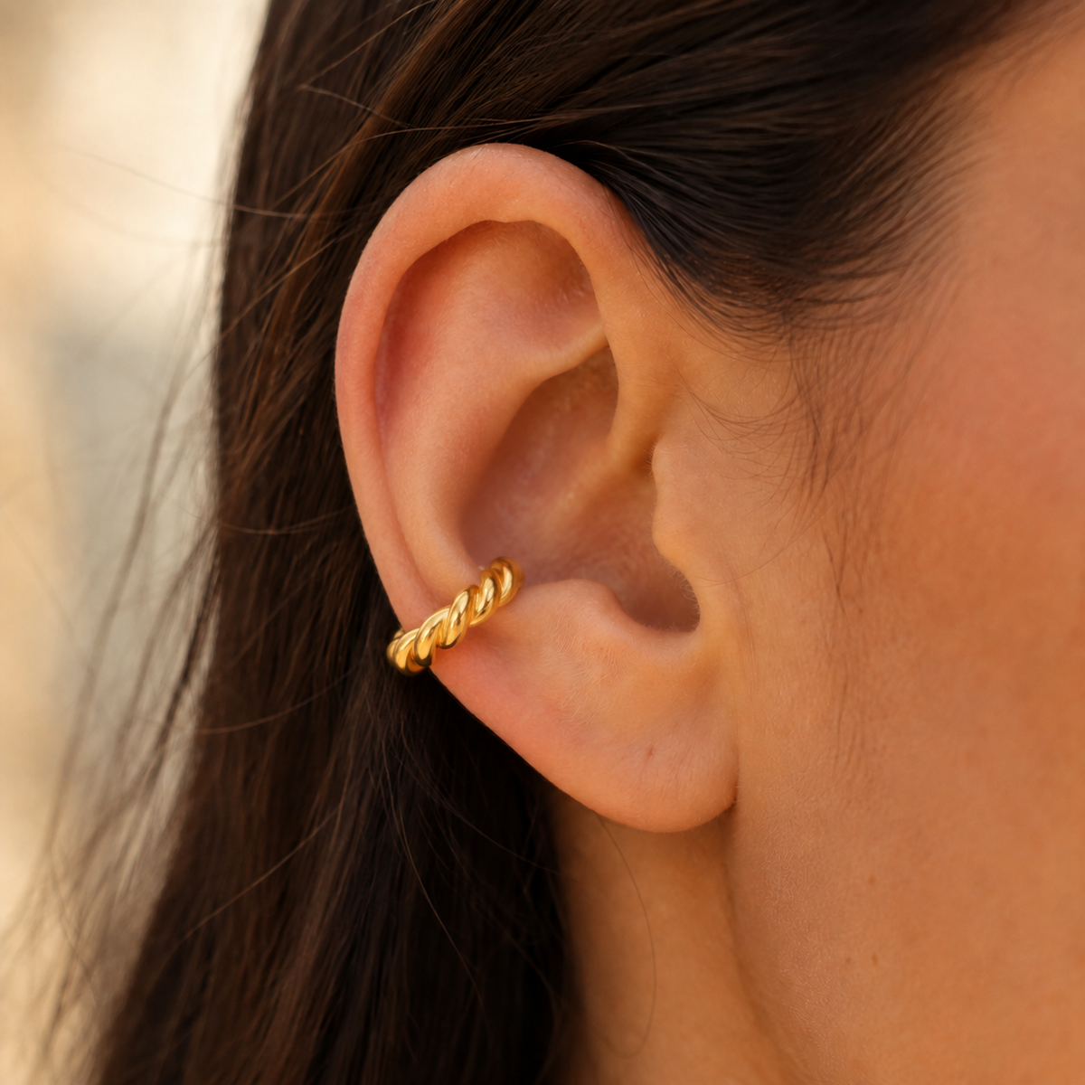 Bague d’oreille torsadée dorée sans perçage portée sur le cartilage