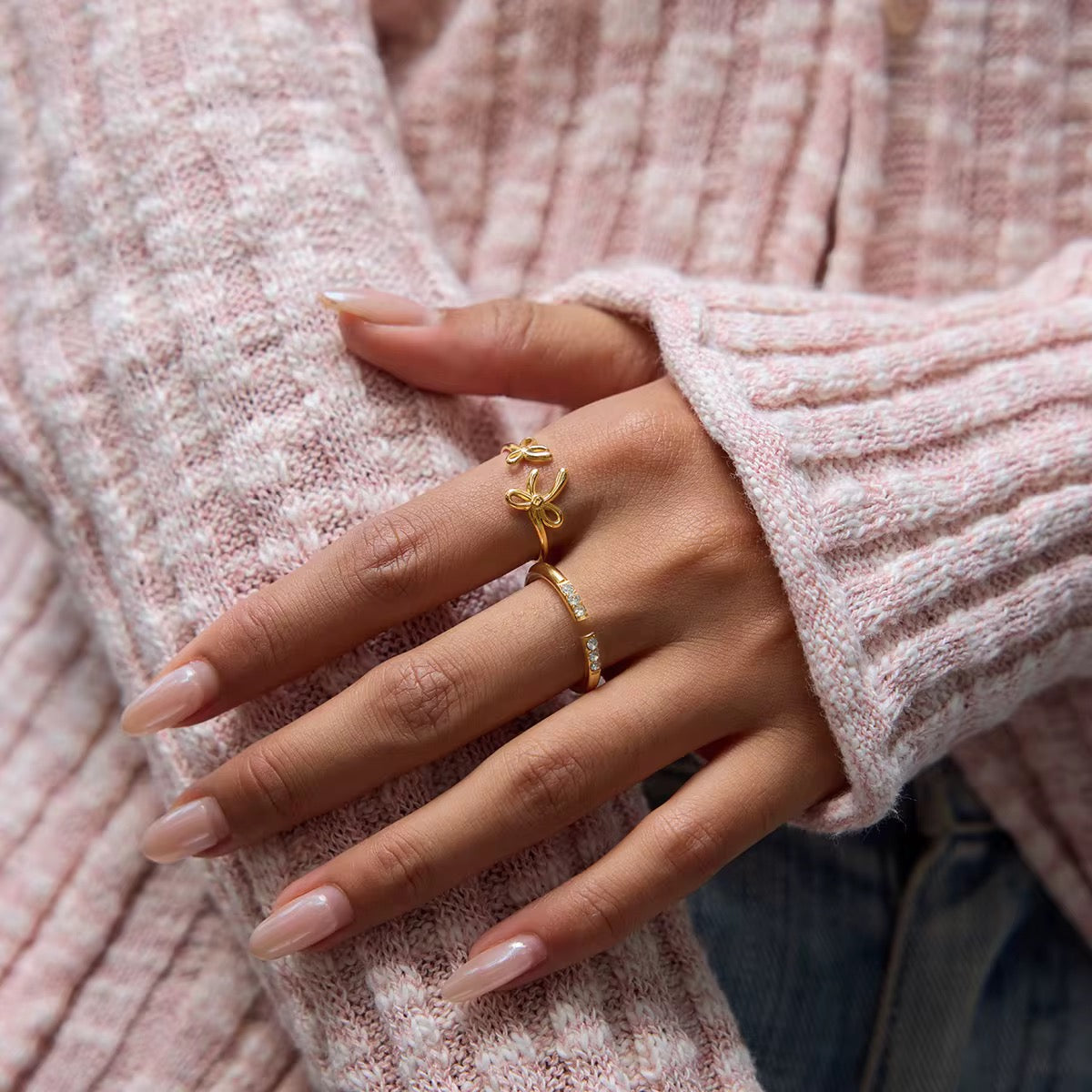 Bague ruban portée par une femme avec un pull