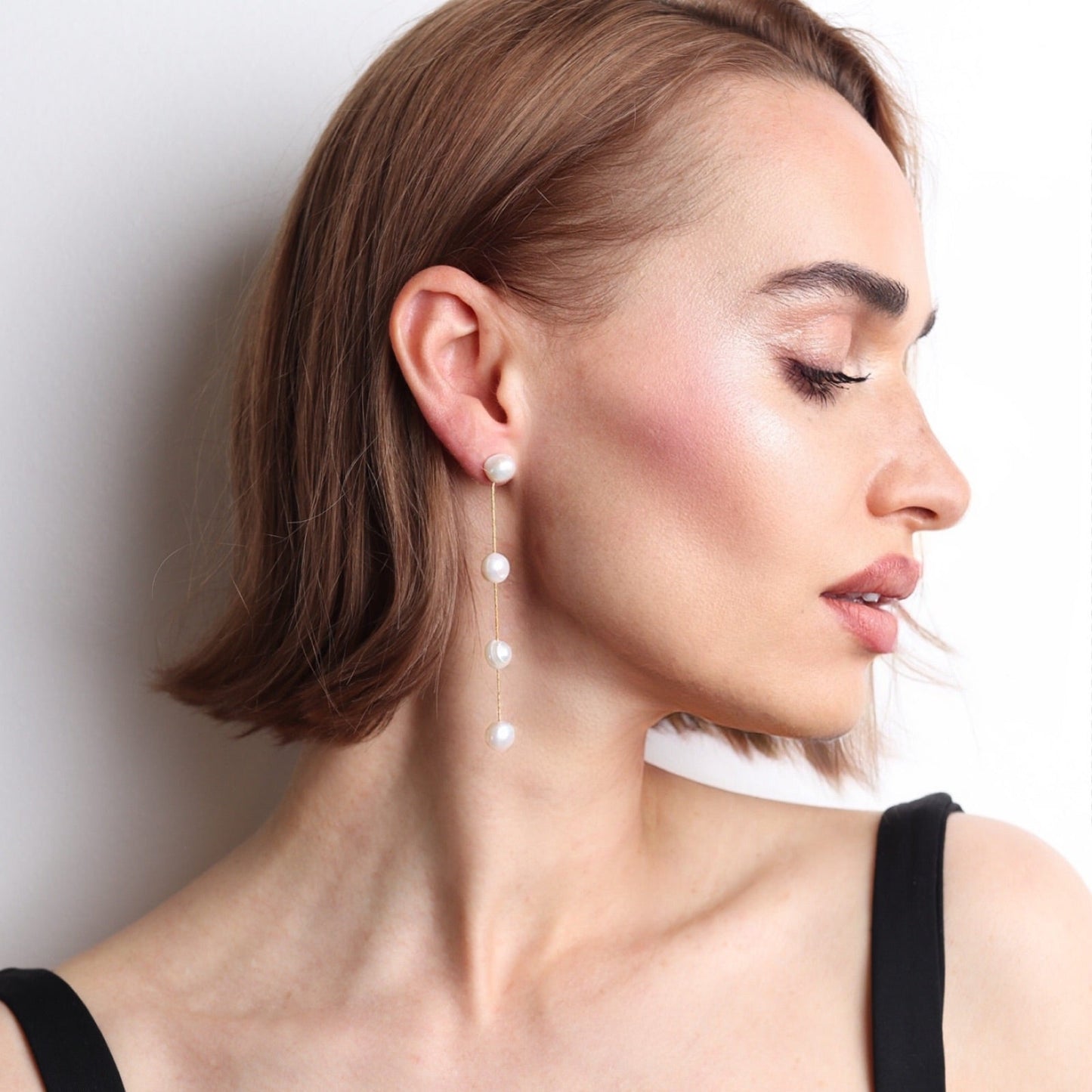 Boucles d’oreilles longues en perles naturelles blanches et finition dorée pour mariée