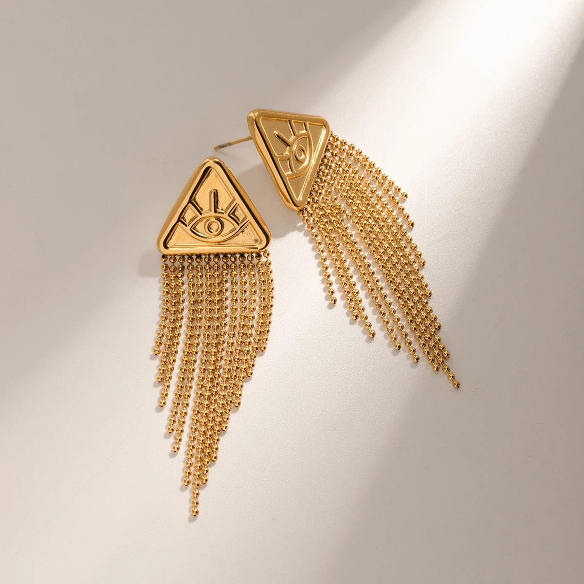 Paire de boucles d'oreilles pendantes dorées avec motif oeil et franges en chaînes