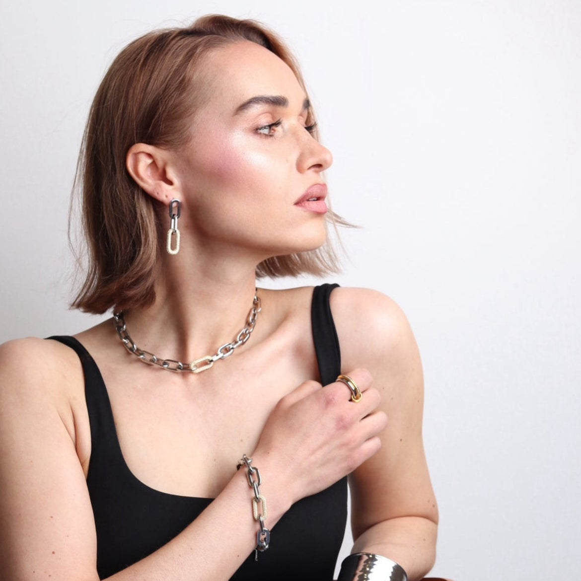 Boucles d’oreilles argentées et zirconium portées par une femme