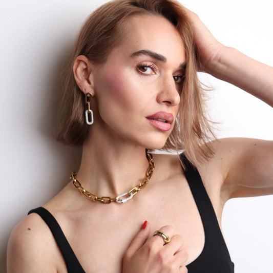 Boucles d’oreilles dorées et zirconium portées par une femme