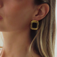 Boucle d'oreille Marylou dorée à pierre noire portée, cheveux longs blonds