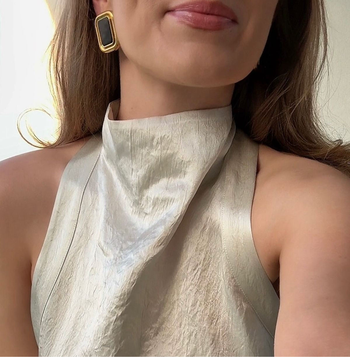 Boucles d'oreilles vintage Marylou portées avec un haut satiné ivoire à col montant