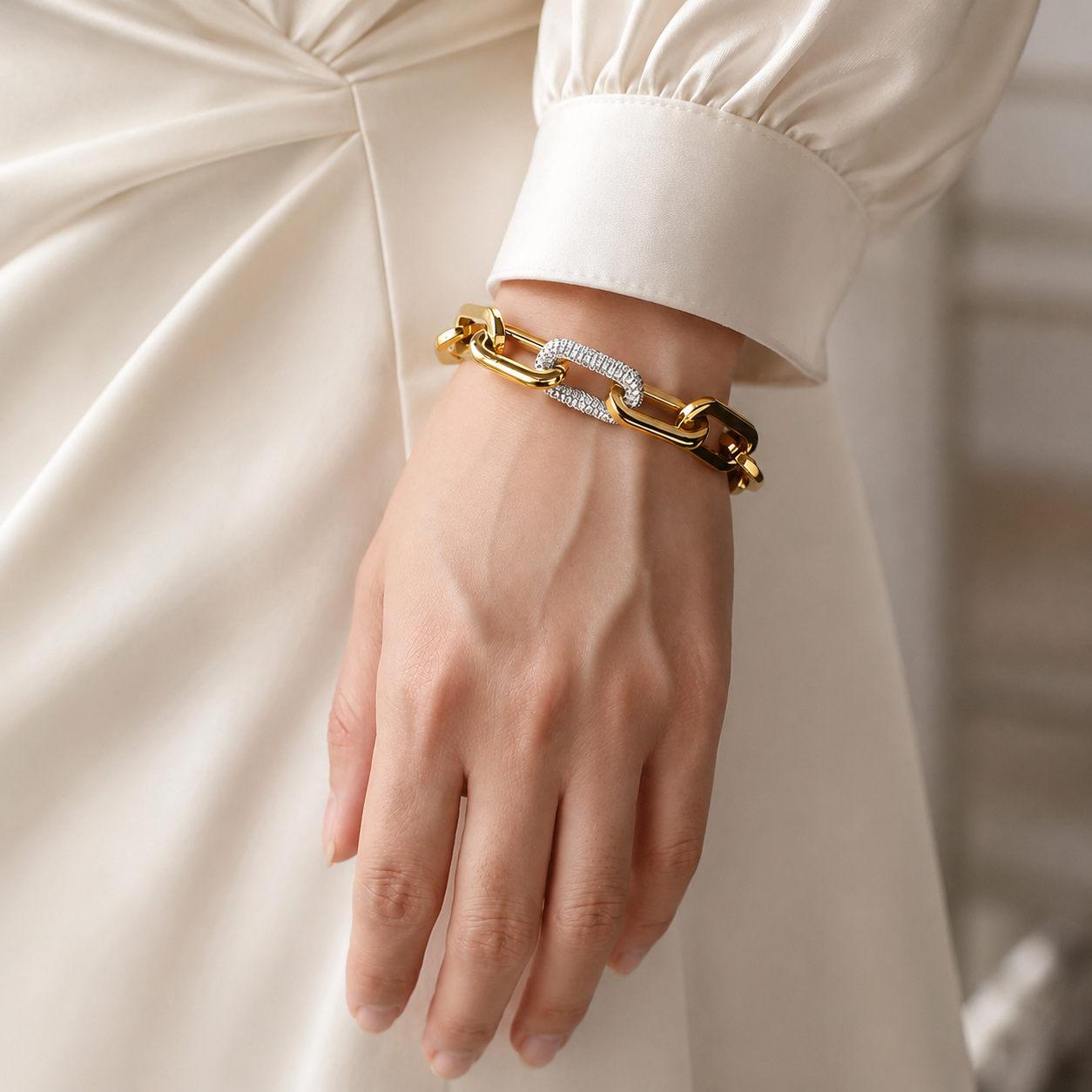 Bracelet doré à grosse maille avec fermoir pavé brillant porté avec une tenue élégante