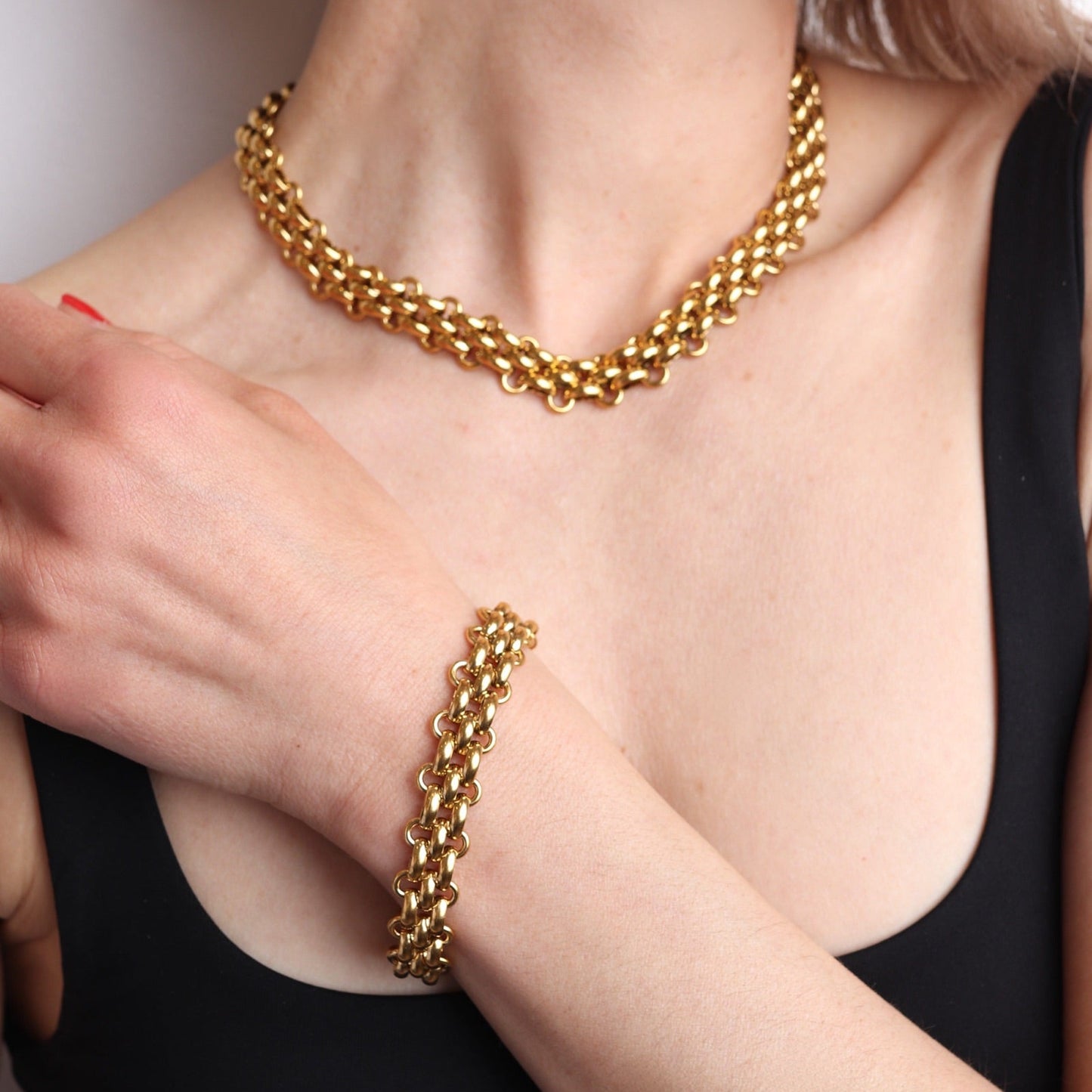 Bracelet doré vintage porté au poignet avec collier assorti
