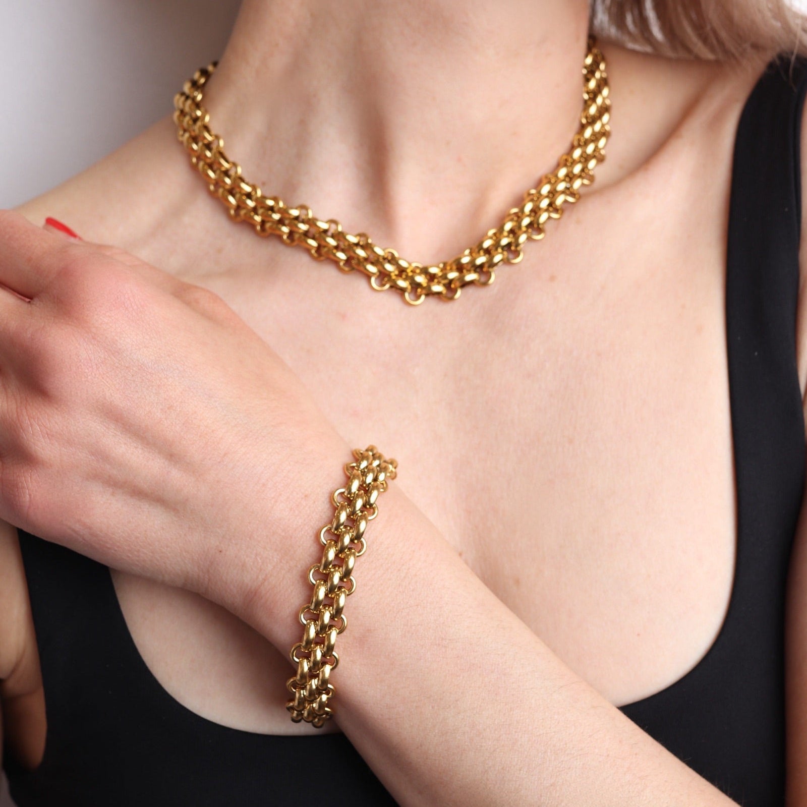 Bracelet doré vintage porté au poignet avec collier assorti