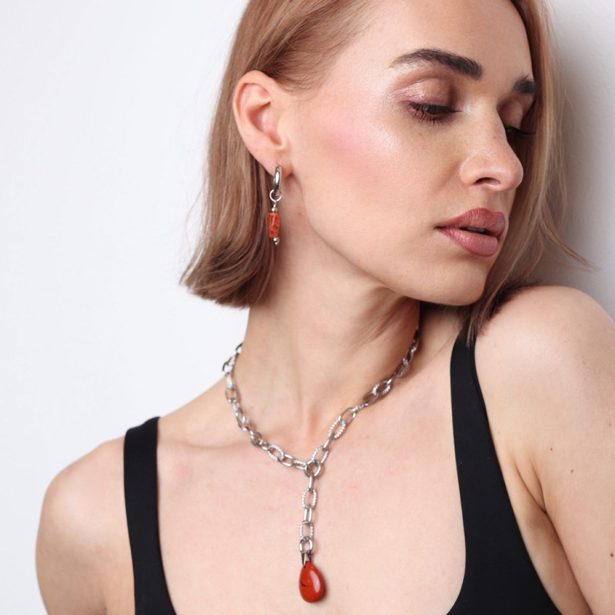 Femme portant un collier argent avec pendentif pierre rouge