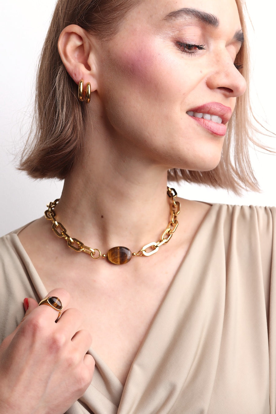 Collier interchangeable Camille doré, grosse maille lisse de style moderne, porté avec une pierre œil de tigre au centre