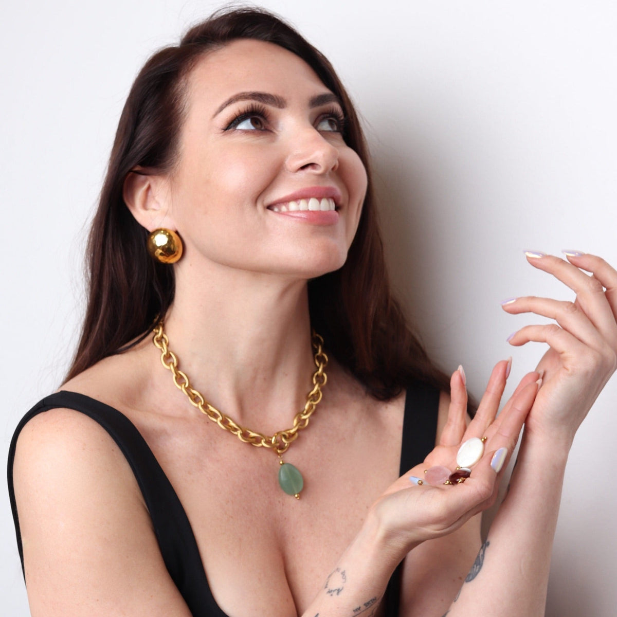 Femme portant un collier doré avec pendentif pierre verte naturelle
