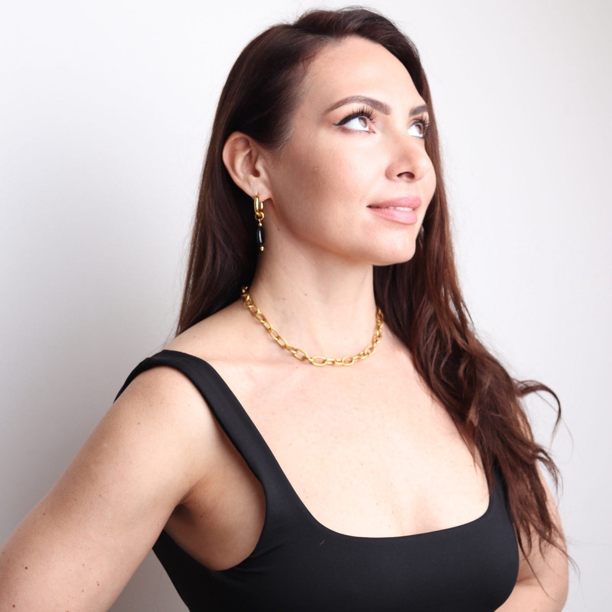 Femme portant un collier minimaliste doré avec pierre noire naturelle