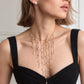 Collier plastron perles naturelles Séraphine doré porté avec une robe noire et des puces perle