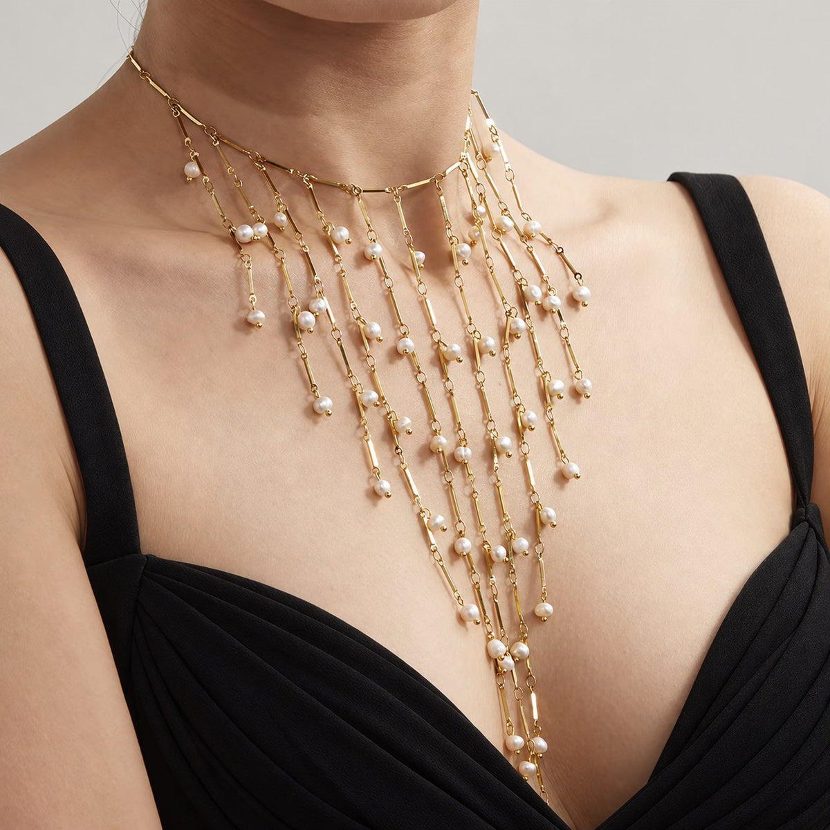 Collier plastron Séraphine doré porté de trois quarts, longue frange de perles naturelles