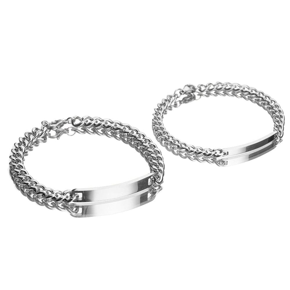 Paire de gourmettes couple Le Duo couleur argentée en acier inoxydable sur fond blanc